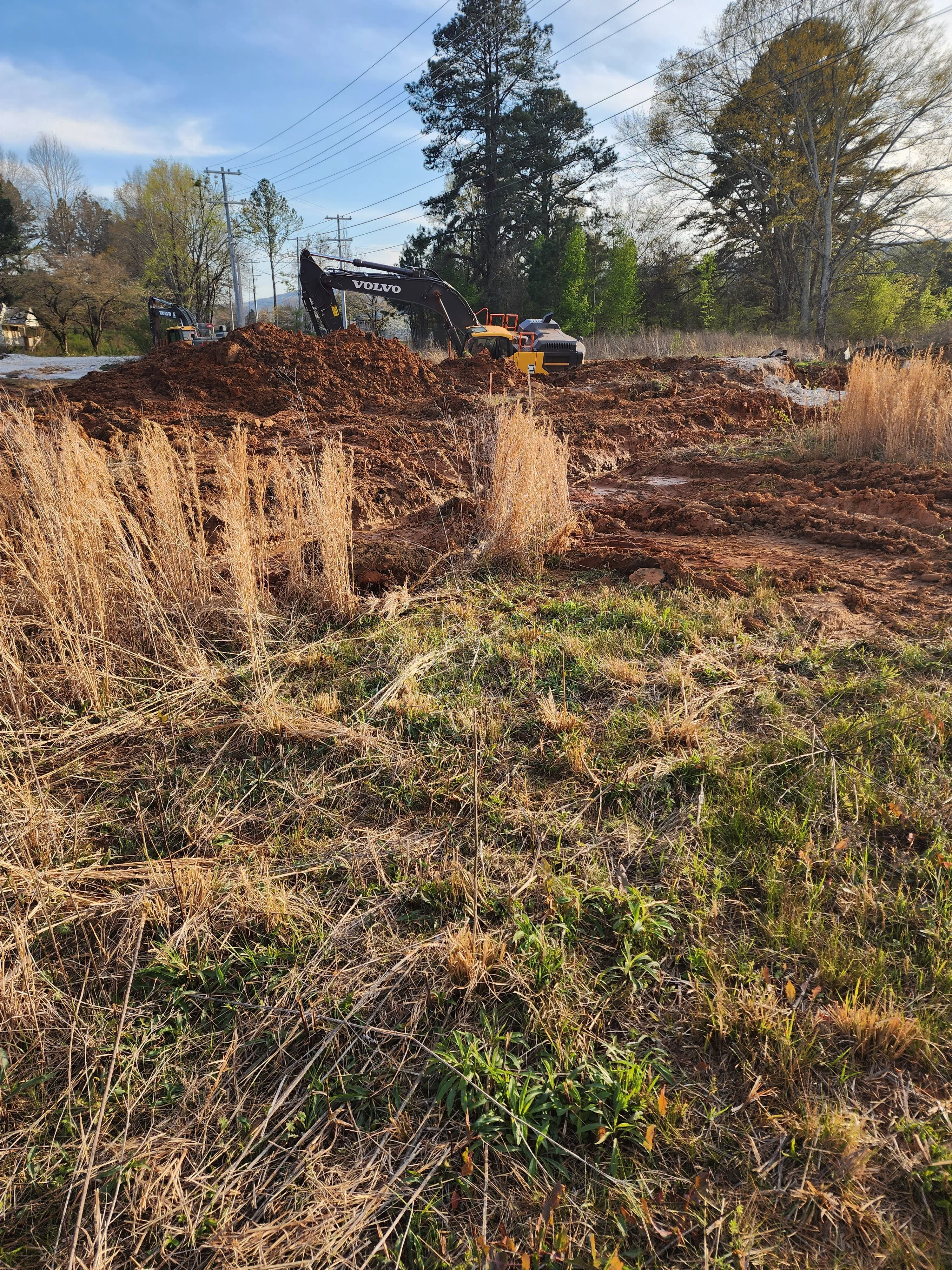 Volvo excavator moving earth during site excavation and grading project in Toney, Alabama