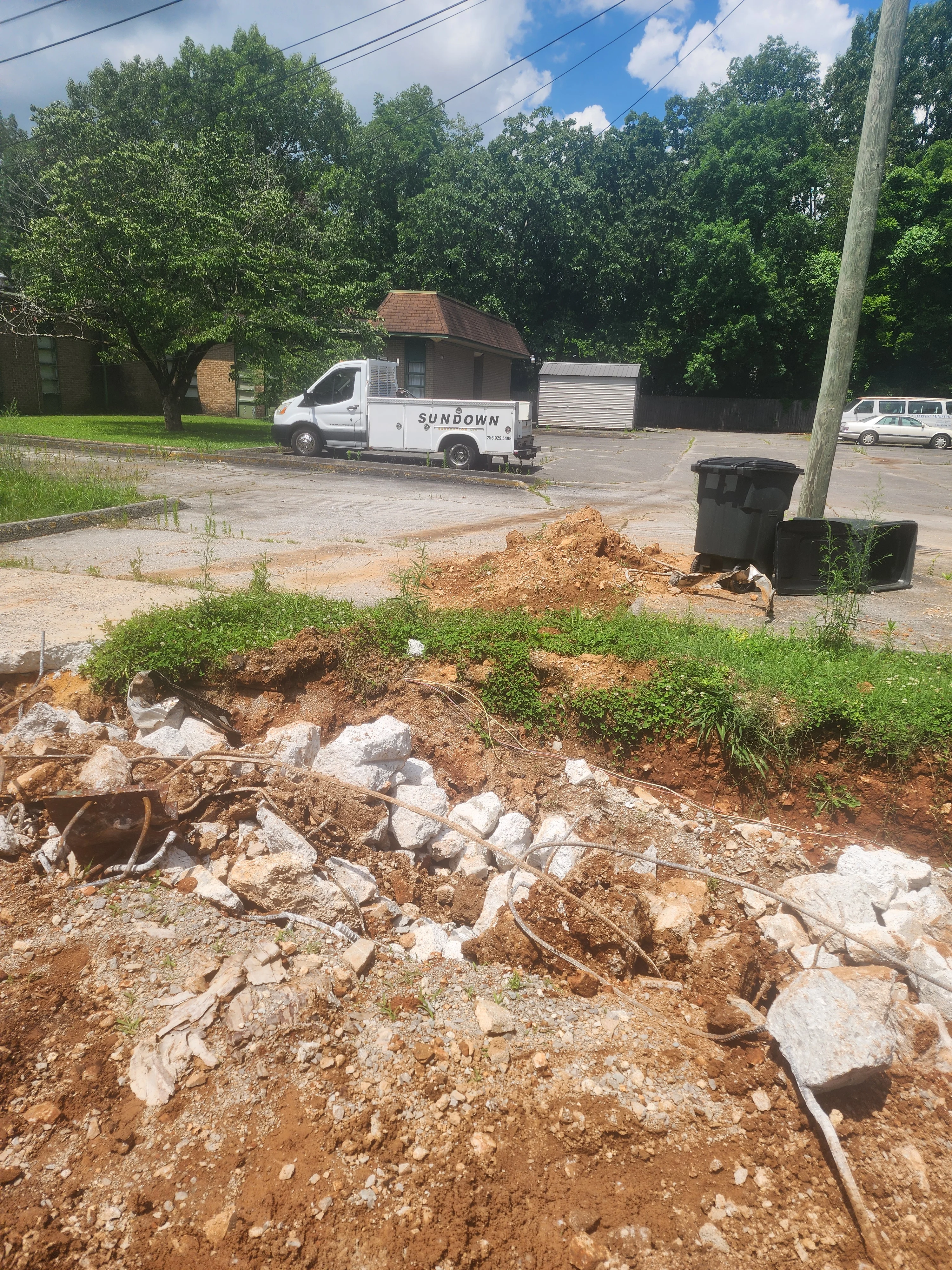 Residential excavation site with exposed earth, rocks, and Sundown Excavation truck