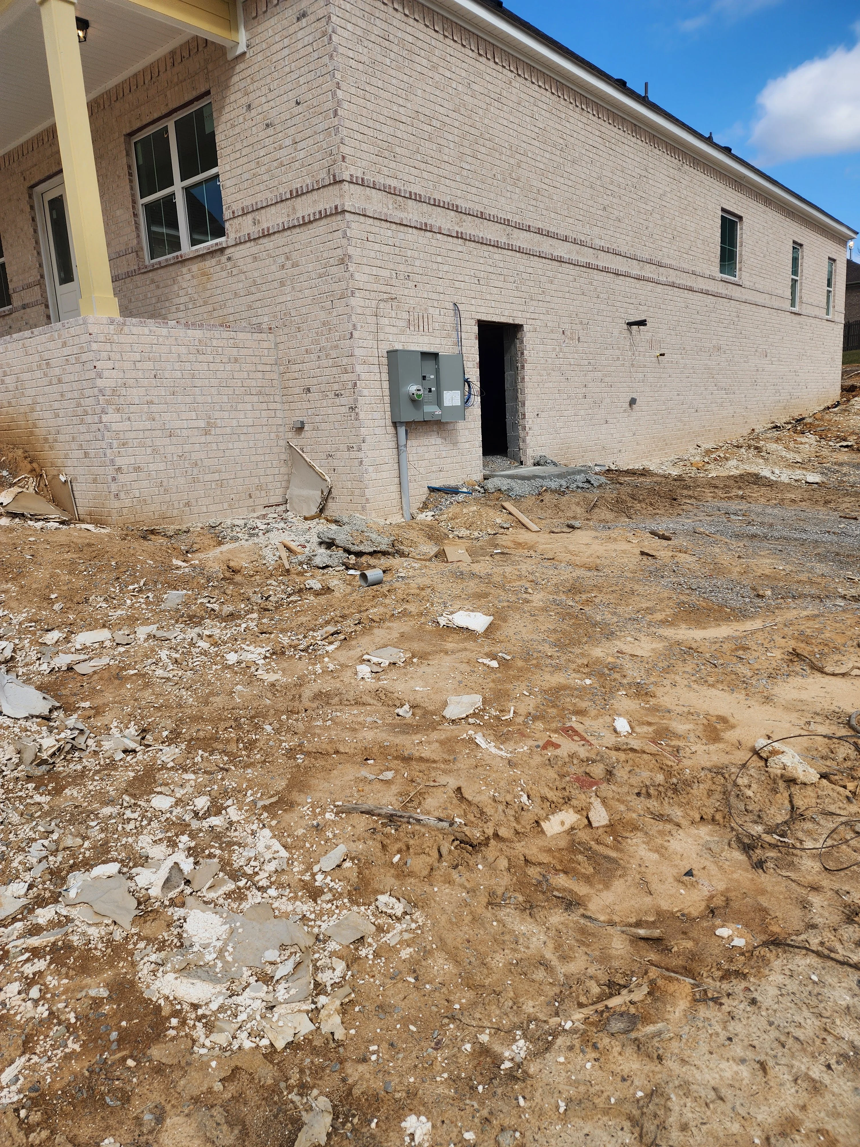 Excavated residential lot with brick home foundation and utility box installation