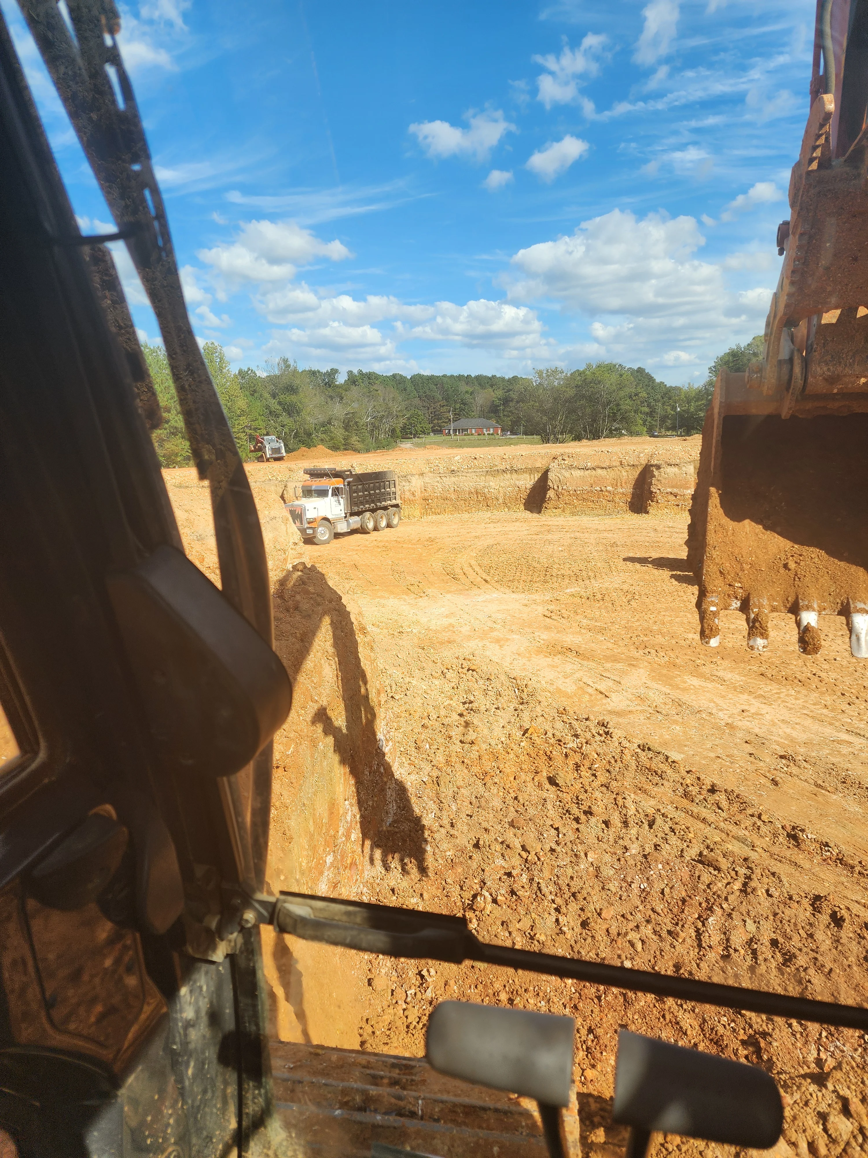 Excavation site with heavy equipment and graded red clay soil in Toney, Alabama