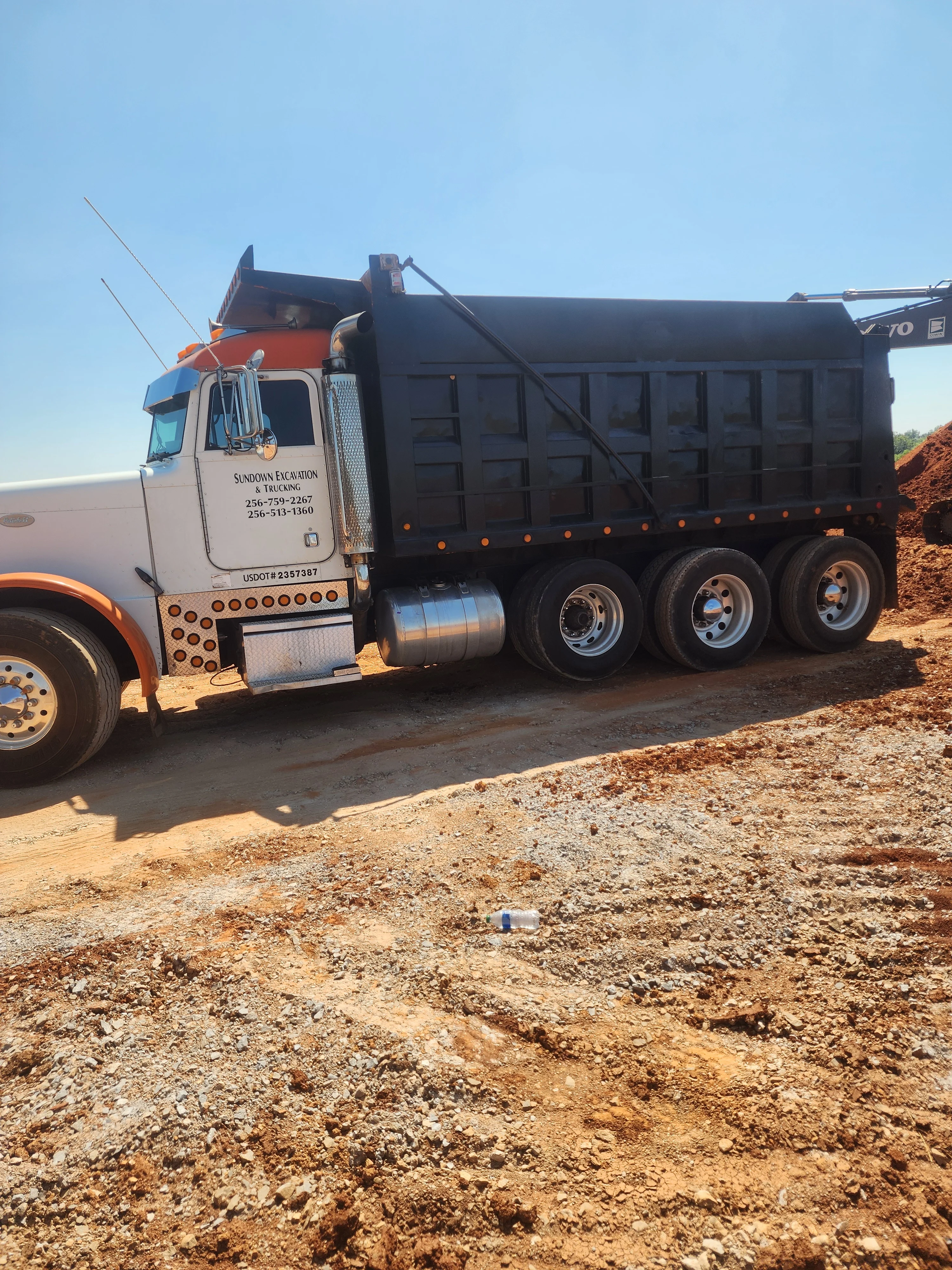 Tri-axle dump truck loaded with excavated soil at active construction site